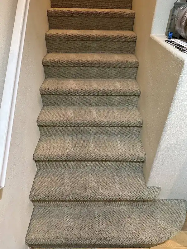 Beige loop-pile staircase after cleaning, every tread groomed in one direction