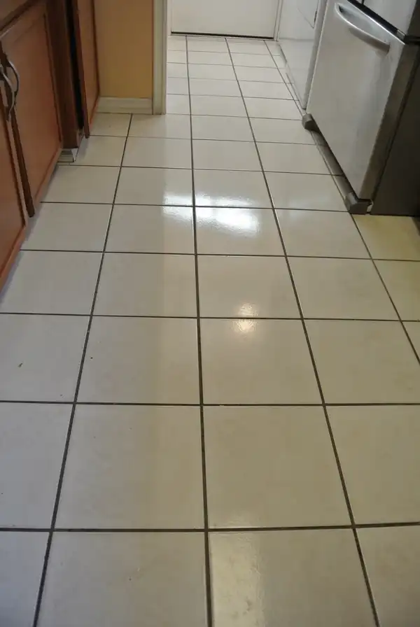 Cream ceramic galley kitchen tile with dark, dingy grout lines before cleaning