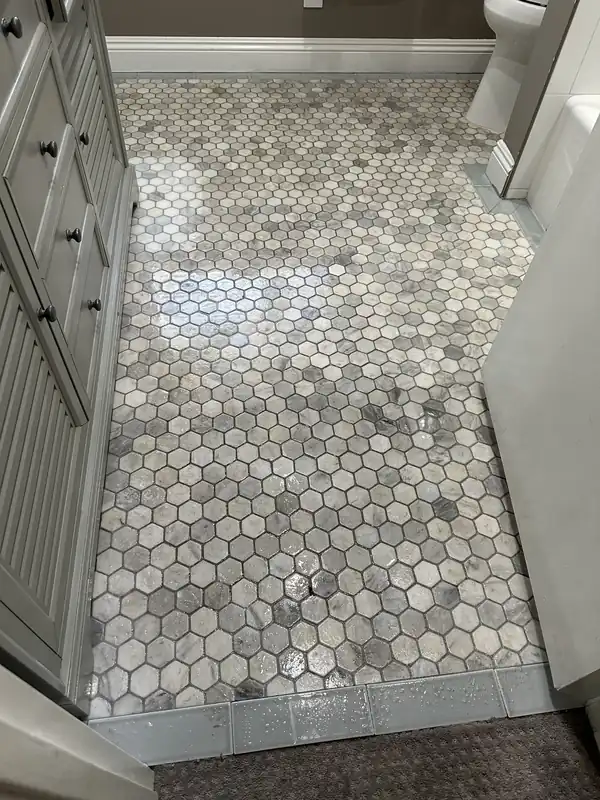 Marble hexagon mosaic bathroom floor with grimy grout before cleaning