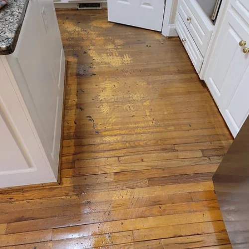 Oak strip hardwood kitchen floor with a dull, cloudy finish before cleaning